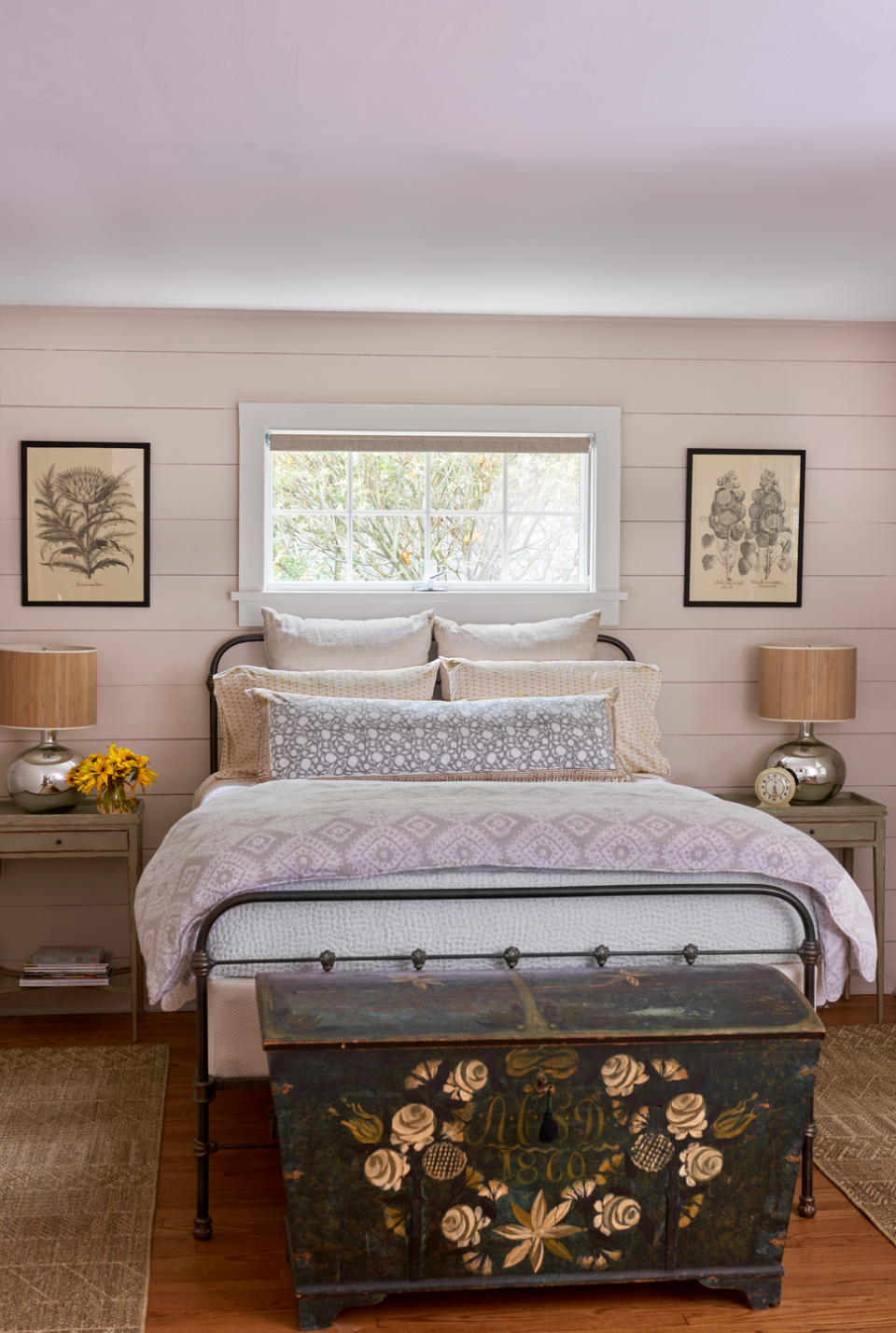 farmhouse bedroom filled with pretty textiles and an antique trunk