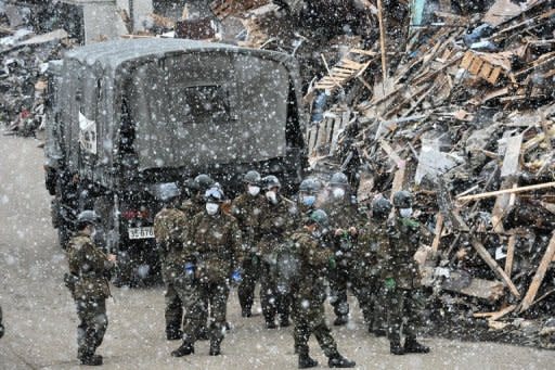 Members of the Japanese Self-Defense Forces gather for a briefing in the snow in Tarou, north of Morika, in Iwate prefecture, 12 days after the devastating earthquake and tsunami. The grim toll of dead and missing from Japan's monster quake and tsunami on March 11 topped 25,000, as hundreds of thousands remained huddled in evacuation shelters and fears grew in Tokyo over water safety