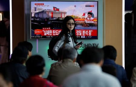 A passenger walks past a TV broadcasting a news report on North Korea's failed missile launch from its east coast, at a railway station in Seoul, South Korea, April 16, 2017. REUTERS/Kim Hong-Ji