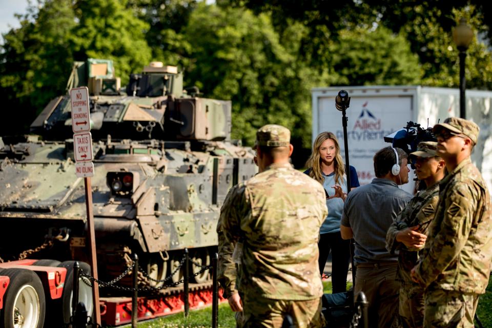 A reporter speaks on camera next to one of two Bradley Fighting Vehicles parked nearby the Lincoln Memorial for President Donald Trump's 'Salute to America' event honoring service branches on Independence Day.