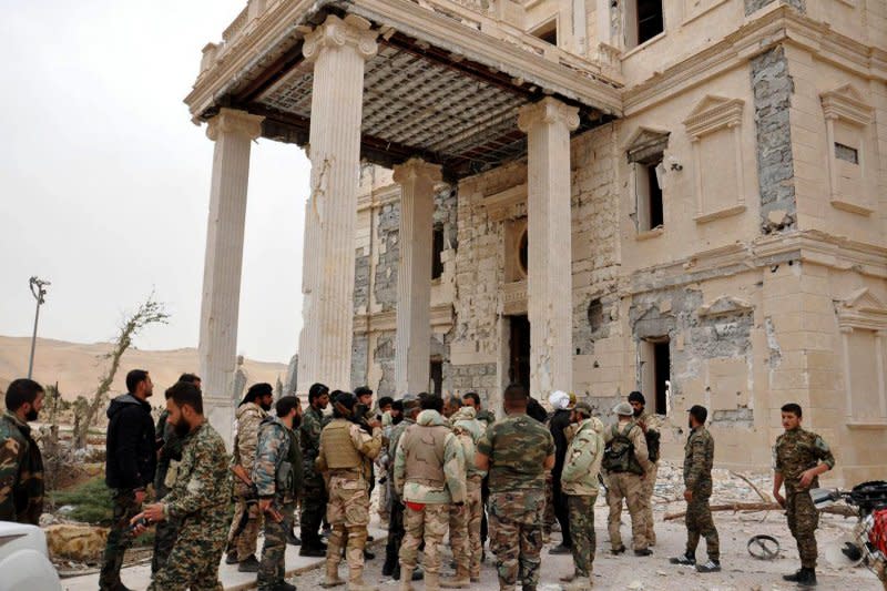 敘利亞政府軍攻進帕米拉古城後，在當地一座受損嚴重的宮殿外聚集整隊。（美聯社）