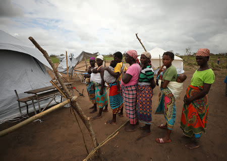 Women and children await medical treatment at a camp for people displaced in flooding in the aftermath of Cyclone Idai, near Beira, Mozambique, March 23, 2019. REUTERS/Mike Hutchings