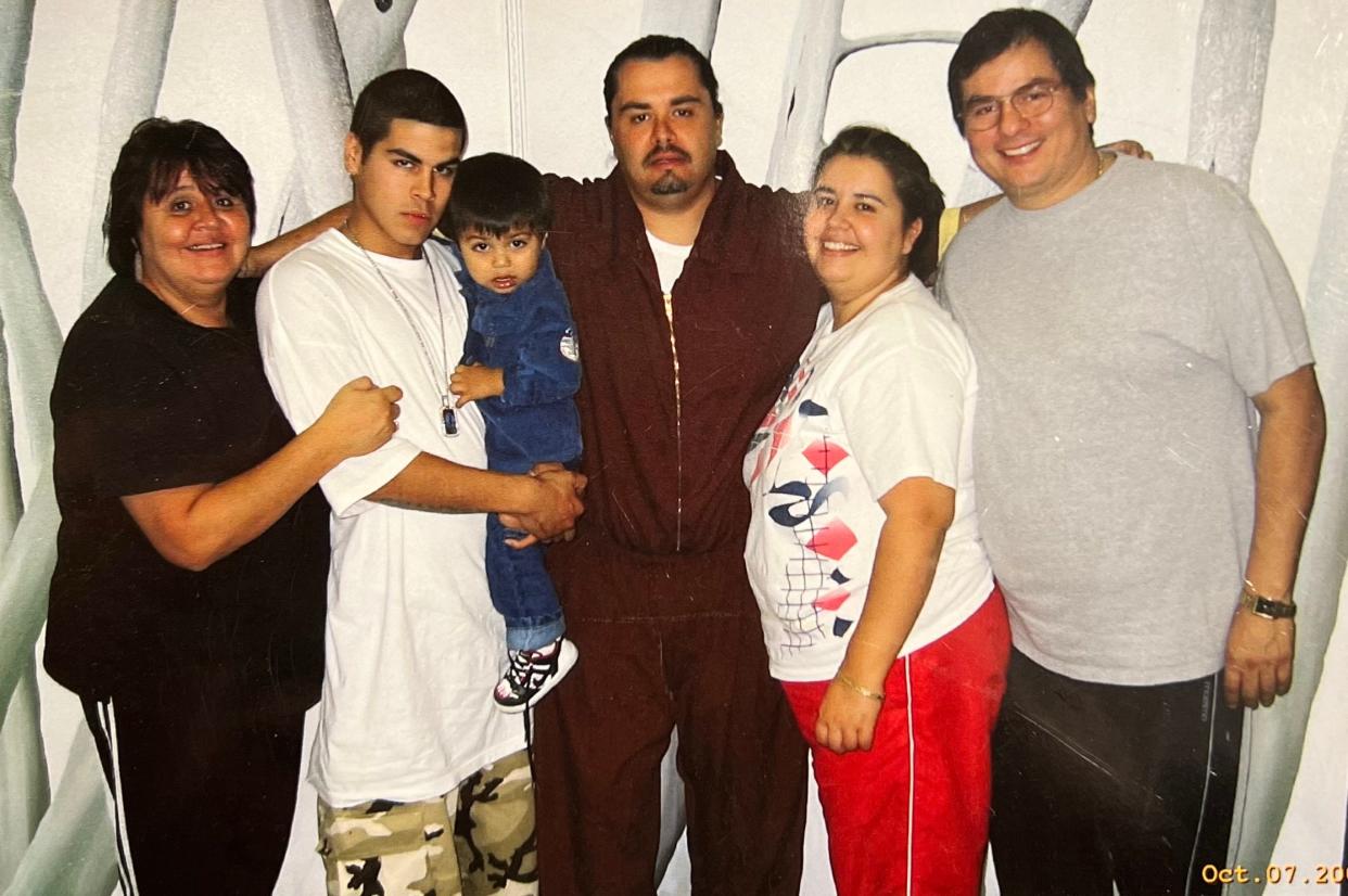 Efrain Hidalgo Jr. (center) is pictured with his family in prison while in his early 30s.