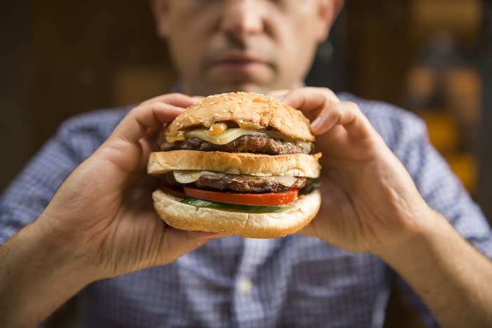 Man about to bite into a burger