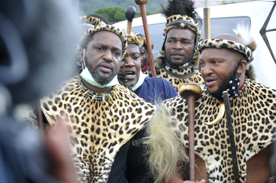 Prince Misuzulu Zulu, left, flanked by fellow warriors in traditional dress at the KwaKhangelamankengane Royal Palace, during a ceremony, in Nongoma, Friday May 7, 2021. A new Zulu king in South Africa has been named amid scenes of chaos as other members of the royal family questioned Prince Misuzulu Zulu’s claim to the title. He was suddenly whisked away from the public announcement at a palace by bodyguards. The controversy over the next king has arisen after the death in March of King Goodwill Zwelithini, who had reigned since 1968. Zwelithini apparently named one of his six wives, Queen Mantfombi Shiyiwe Dlamini Zulu, as the “regent of the Zulu kingdom” in his will. But her death just over a week ago after holding the title for only a month has thrown the royal succession into turmoil. (AP Photo)