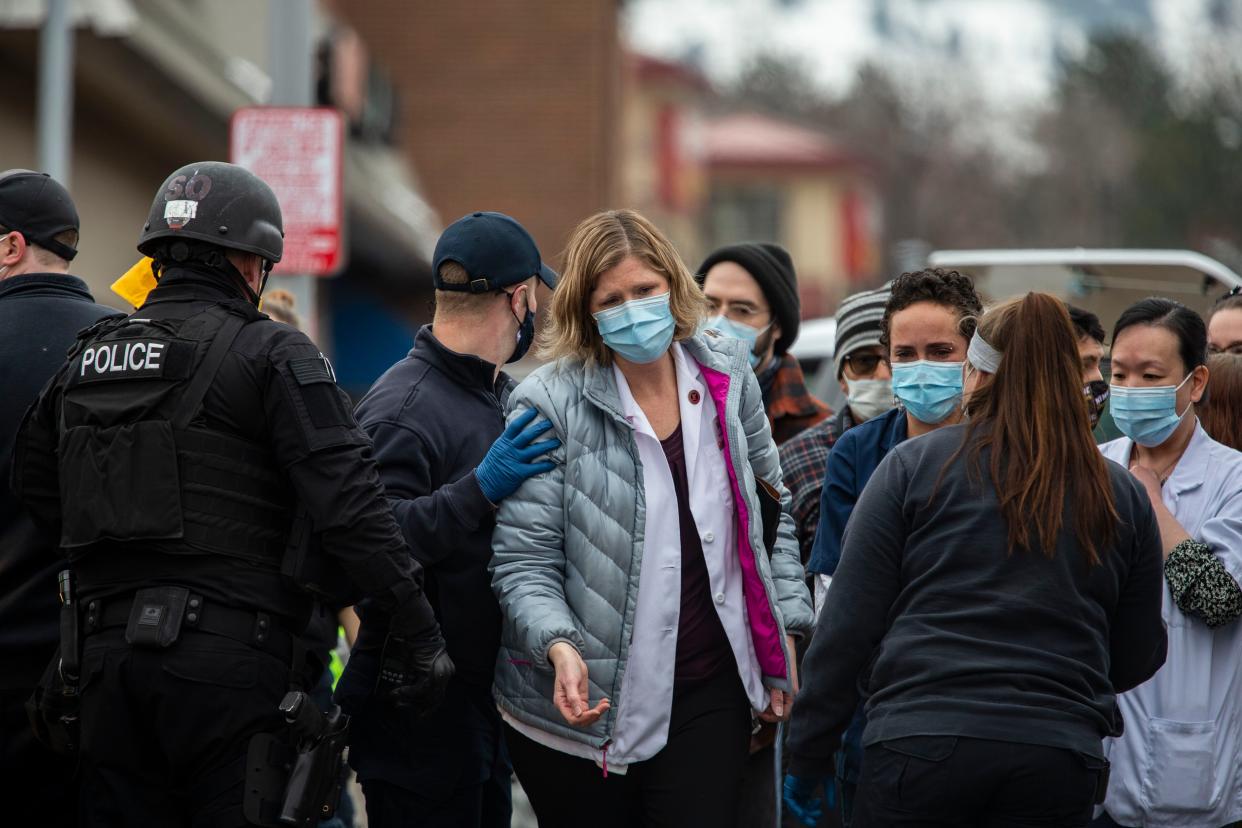 Healthcare workers walk out of a King Soopers Grocery store after a gunman opened fire on March 22, 2021, in Boulder, Colorado. Dozens of police responded to the afternoon shooting in which at least one witness described three people who appeared to be wounded, according to published reports.