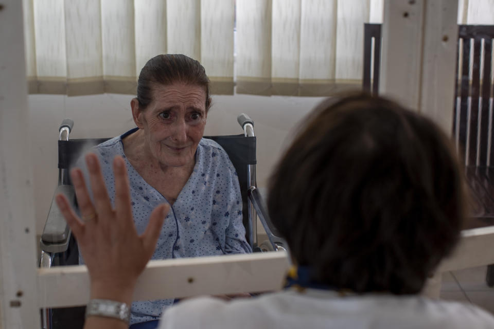 Rafka Nassim, 71, left, meets with her daughter Claudette Rizk through a plastic barrier to avoid contracting the coronavirus, at the Social Services Medical Association, a rehabilitation hospital and nursing home in the northern city of Tripoli, Lebanon, Thursday, June 10, 2021. With virtually no national welfare system, Lebanon’s elderly are left to fend for themselves amid their country’s economic turmoil. (AP Photo/Hassan Ammar)