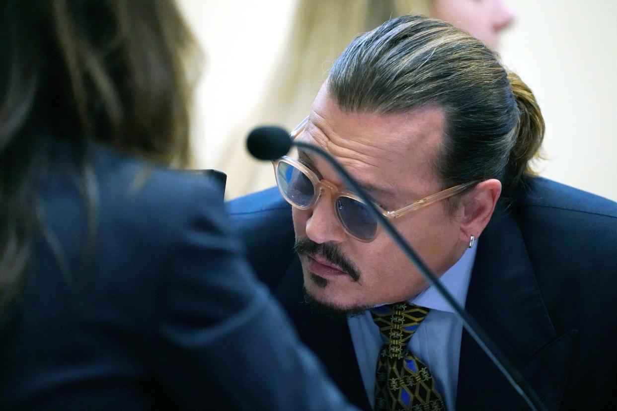 Johnny Depp talks to his attorney, in the courtroom at the Fairfax County Circuit Courthouse in Fairfax, Va., Monday, May 23, 2022.