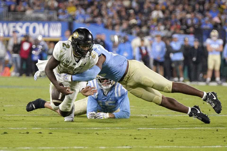 Colorado quarterback Shedeur Sanders, left, fumbles the ball as UCLA defensive lineman Gabriel Murphy, right, tackles him during the second half of an NCAA college football game Saturday, Oct. 28, 2023, in Pasadena, Calif. Sanders recovered the ball. (AP Photo/Mark J. Terrill)