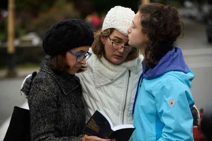 <p>Tammy Hepps, Kate Rothstein and her daughter, Simone Rothstein, 16, pray from a prayerbook a block away from the site of a mass shooting at the Tree of Life Synagogue in the Squirrel Hill neighborhood on Oct. 27, 2018 in Pittsburgh, Pa. (Photo: Jeff Swensen/Getty Images) </p>