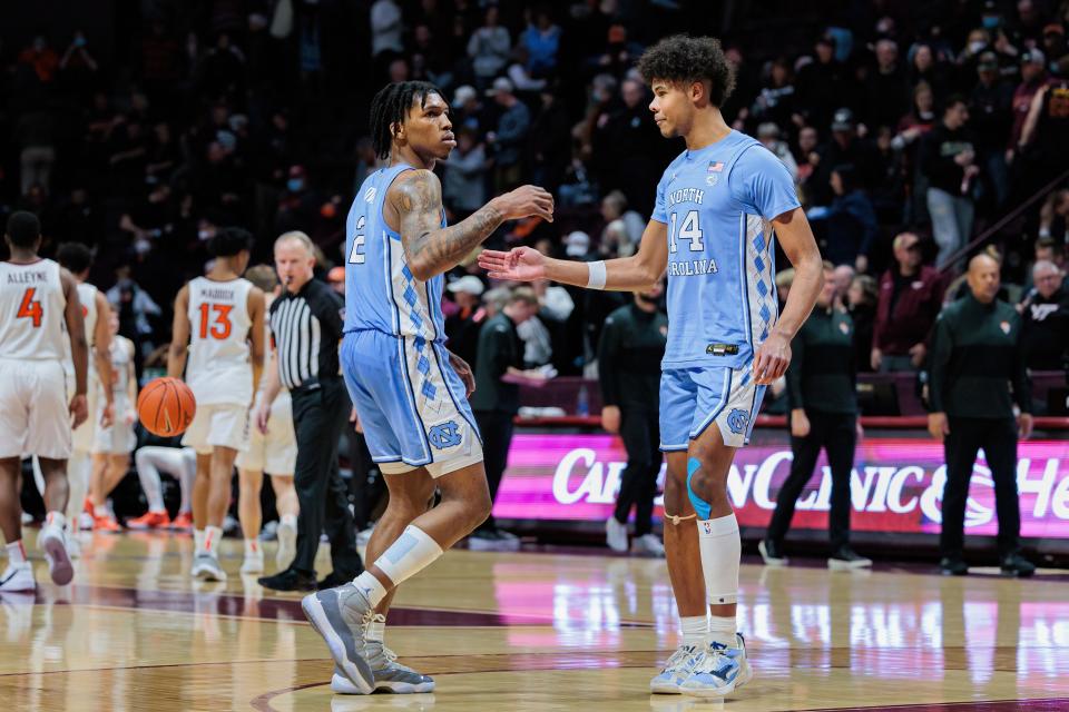 Feb 19, 2022; Blacksburg, Virginia, USA; North Carolina Tar Heels guard Caleb Love (2) and guard Puff Johnson (14) celebrate following a win against the Virginia Tech Hokies at Cassell Coliseum.