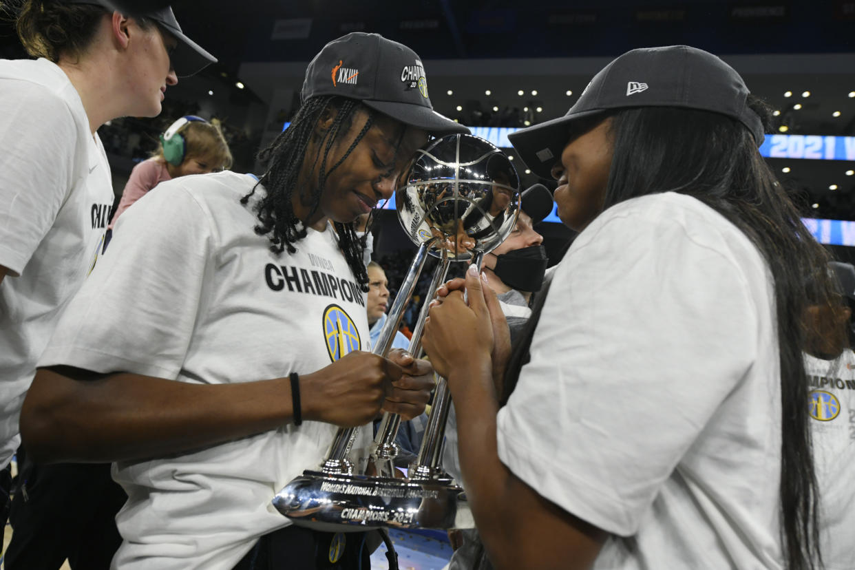 Chicago Sky's Diamond DeShields left, and Lexie Brown right, celebrate with the trophy after defeating the Phoenix Mercury 80-74 in Game 4 of the WNBA Finals to become the 2021 WNBA champions Sunday, Oct. 17, 2021, in Chicago. (AP Photo/Paul Beaty)