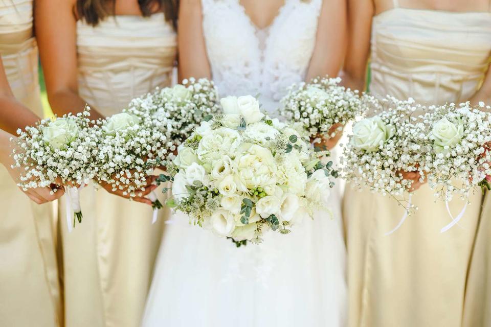 <p>Csatary Photo/Getty</p> Stock photo of a bride with bridesmaids