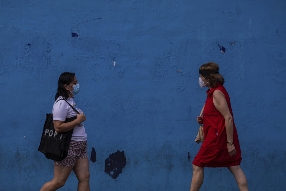 Two woman wearing face masks to prevent the spread of coronavirus walk in the southern neighbourhood of Vallecas in Madrid, Spain, Wednesday, Sept. 16, 2020. The Spanish capital will introduce selective lockdowns in urban areas where the coronavirus is spreading faster, regional health authorities announced on Tuesday. The measures in Madrid will most likely affect southern, working-class neighbourhoods where virus contagion rates have been steadily soaring since August. (AP Photo/Bernat Armangue)