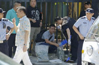 <p>Crime scene police put tree leaves into a bag near the blast site outside the U.S. Embassy in Beijing, Thursday, July 26, 2018. (Photo: Andy Wong/AP) </p>