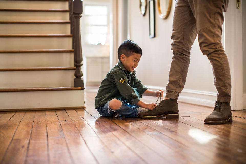 A child unlacing a person's shoe