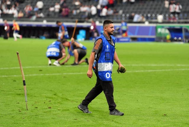 Ground staff work on the pitch at the Frankfurt Arena