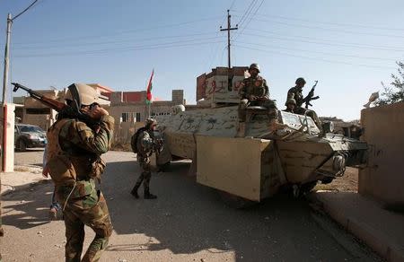 Syrian Kurdish fighters ride a military vehicle in the town of Bashiqa, after it was recaptured from the Islamic State, east of Mosul, Iraq, November 12, 2016. Picture taken November 12, 2016. REUTERS/Azad Lashkari