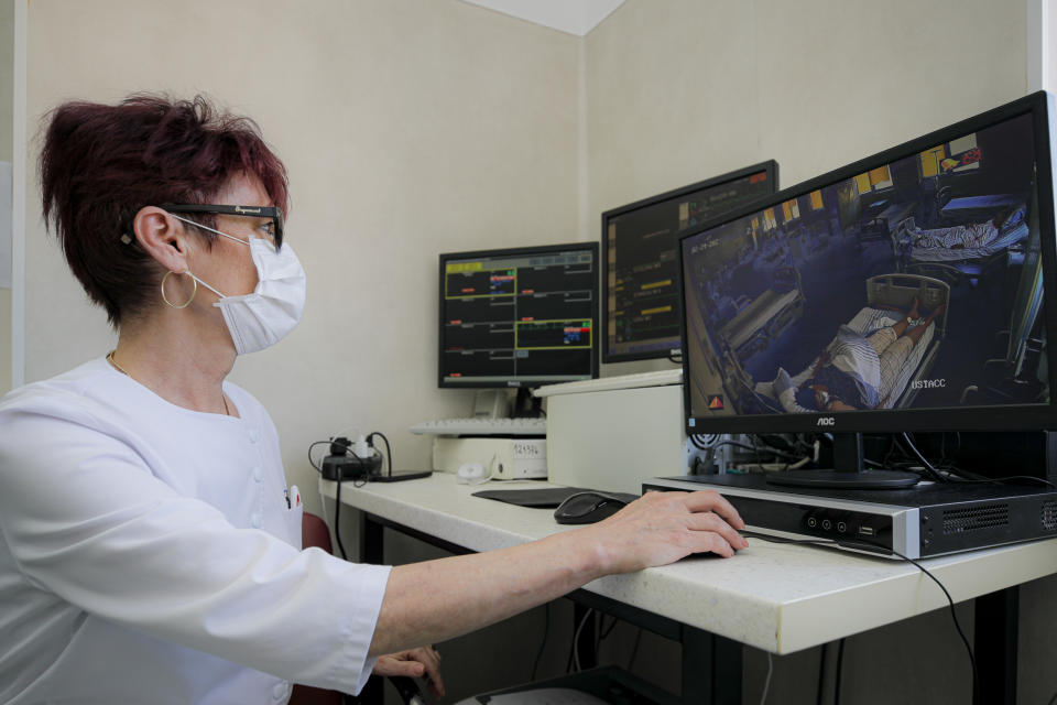 Medical staff monitor COVID-19 patients, at the Colentina Hospital in Bucharest, Romania, Thursday, Feb. 25, 2021. A year ago, Romania reported its first case of COVID-19, prompting the country's strapped medical system to turn its focus to treating COVID-19 patients. As a result, many patients with other conditions — including HIV but also cancer and other illnesses — have either been denied critical care or stopped going to their regular appointments, fearful of becoming infected.(AP Photo/Vadim Ghirda)