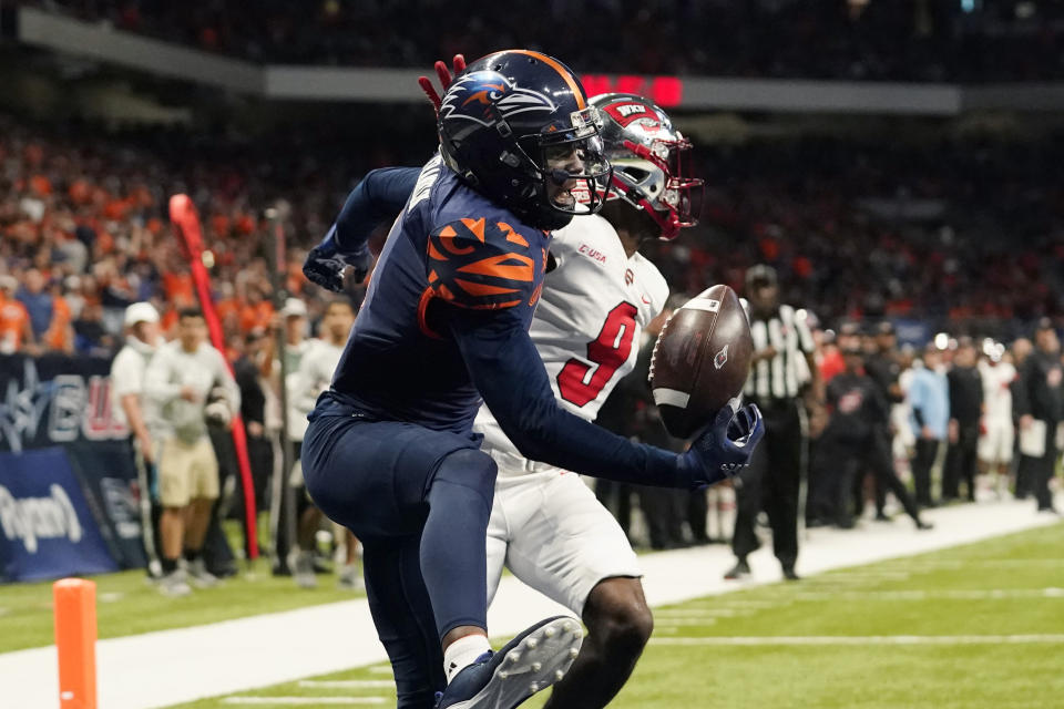 UTSA wide receiver Zakhari Franklin (4) pulls in a catch next to Western Kentucky defensive back Dominique Bradshaw (9) for a touchdown during the second half of an NCAA college football game for the Conference USA championship Friday, Dec. 3, 2021, in San Antonio. (AP Photo/Eric Gay)