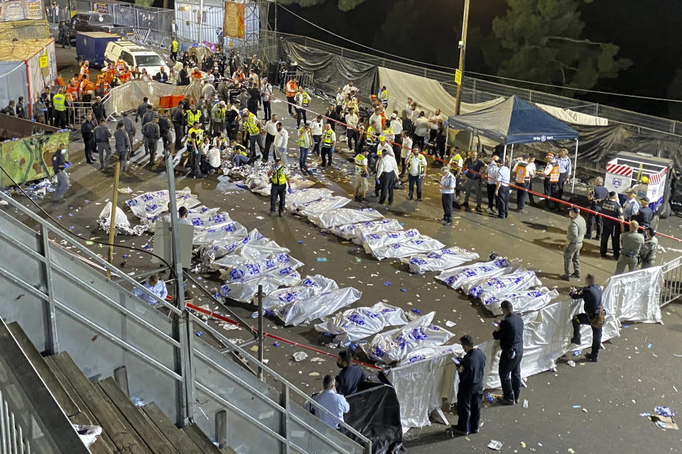 FILE - In this April 30, 2021 file photo, Israeli security officials and rescuers stand around the bodies of victims who died during Lag Baomer celebrations at Mt. Meron in northern Israel. An Israeli government commission investigating the deadly accident held its first day of hearings Sunday, Aug. 22, 2021, almost four months after the stampede at Mount Meron left 45 people dead. The April 29 incident was the deadliest civilian disaster in the country's history. (Ishay Jerusalemite/Behadrei Haredim via AP, File)