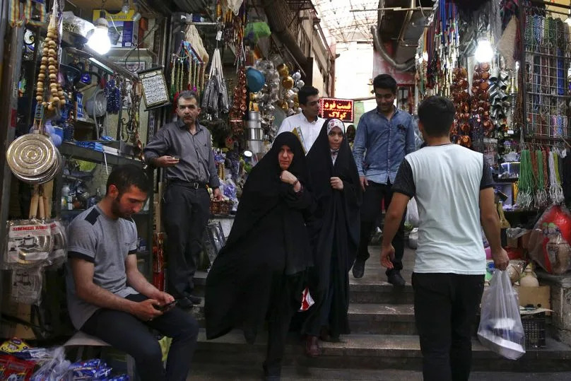 FILE - In this July 19, 2016 file photo, Iranians walk through the Tajrish bazaar in northern Tehran, Iran.