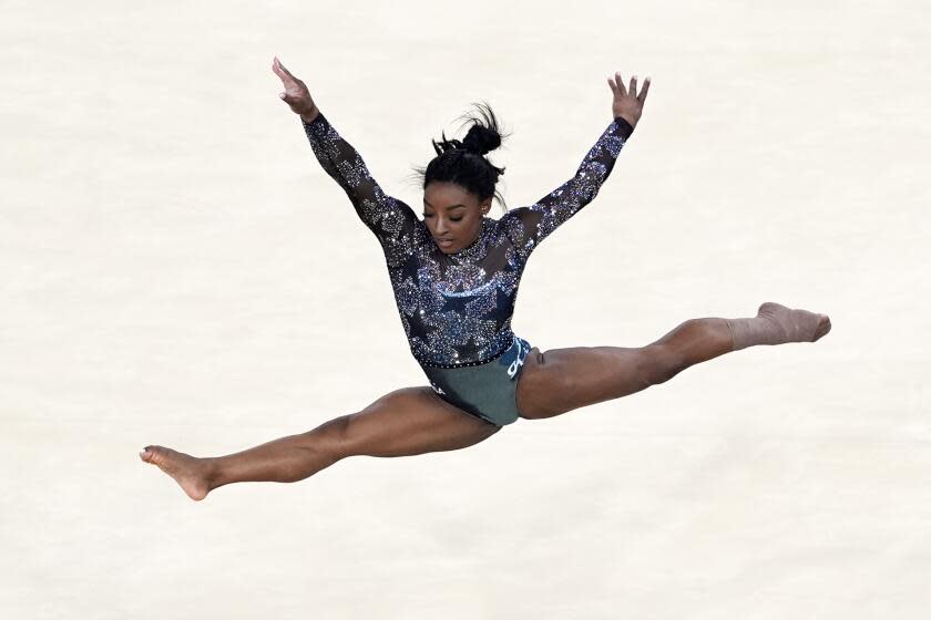 Simone Biles shows her grit, apparent leg injury in