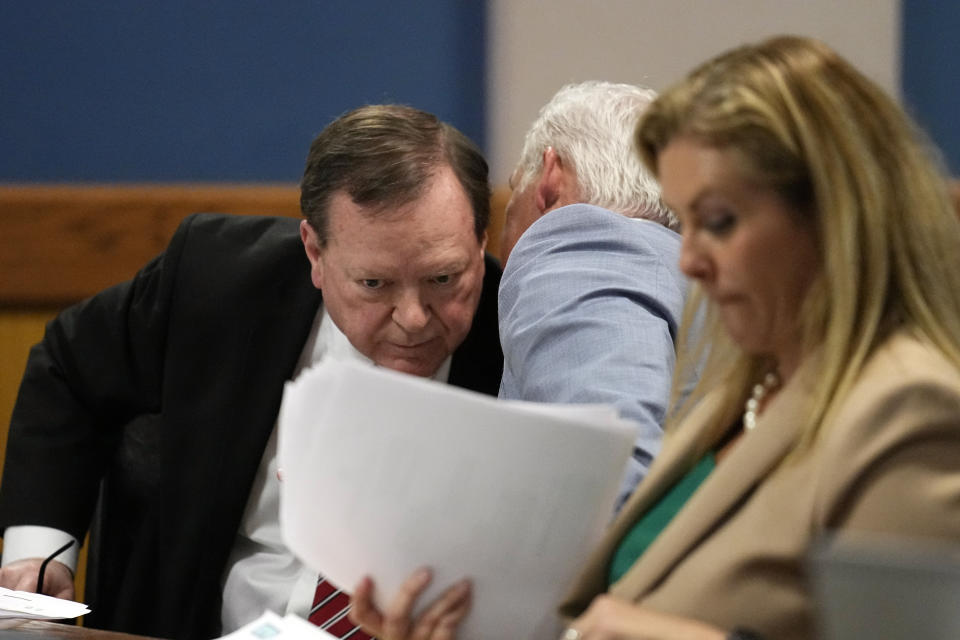 Attorney Craig Gillen, left, and John Merchant confer as attorney Ashleigh Merchant looks over documents duringa hearing in court, Tuesday, Feb. 27, 2024, in Atlanta. Bradley, special prosecutor Nathan Wade’s former law partner and onetime divorce attorney, testified as a judge considered an effort by lawyers for former President Donald Trump to disqualify Fulton County District Attorney Fani Willis over her romantic relationship with Wade. (AP Photo/Brynn Anderson, Pool)