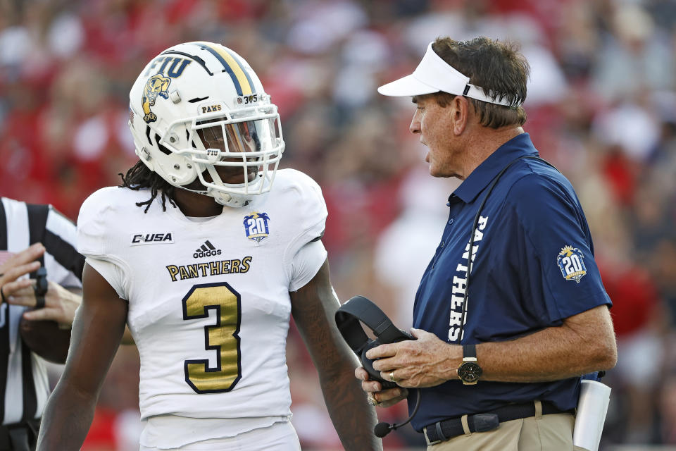 Florida International coach Butch Davis, right, talks to Richard Dames (3) during the first half of an NCAA college football game against Texas Tech, Saturday, Sept. 18, 2021, in Lubbock, Texas. (AP Photo/Brad Tollefson)