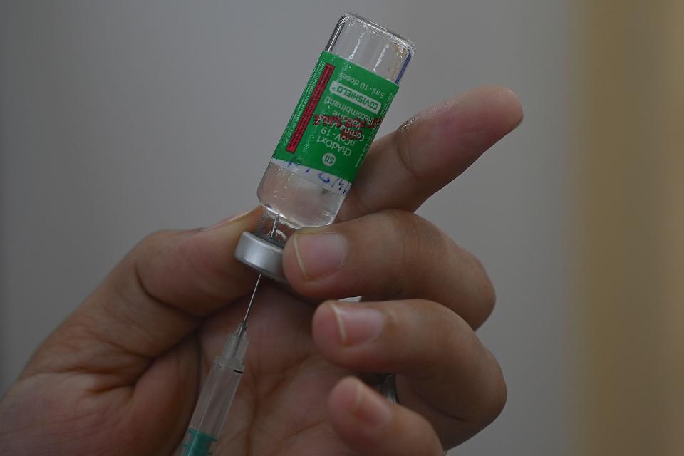 <p>A medical staff fills a syringe with the Covishield at a vaccination centre in Mumbai on 19 April, 2021. </p> (AFP via Getty Images)