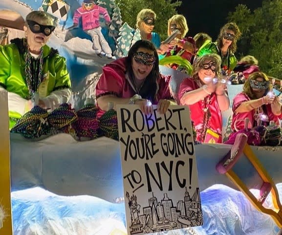 An OOP member holds a sign while standing on a float.