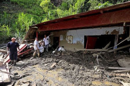 Residents remove debris from their damaged house, after a landslide sent mud and water crashing onto homes close to the municipality of Salgar in Antioquia department, Colombia May 19, 2015. REUTERS/Jose Miguel Gomez