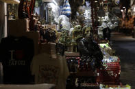 A woman stands outside her nativity scenes shop along San Gregorio Armeno street in Naples, in the Campania region, Italy, Friday, Nov. 13, 2020. The regions of Campania and Tuscany were designated red zone on Friday, signaling the dire condition of a hospitals struggling with a surge of new admissions. (AP Photo/Gregorio Borgia)