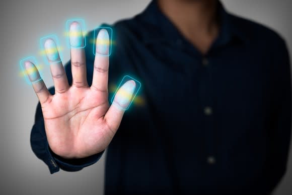 A person putting their hand out having their fingerprints digtally enhanced.