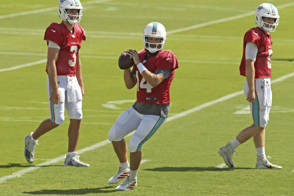 Miami Dolphins quarterbacks Ryan Fitzpatrick (14) Josh Rosen (3) and Jake Rudock (5) run drills during practice in Davie, Fla., Wednesday, Oct. 16, 2019. The winless Miami Dolphins have again changed starting quarterbacks because rookie coach Brian Flores changed his mind. Ryan Fitzpatrick will make his first start since Week 2 when the Dolphins play at Buffalo on Sunday. (David Santiago/Miami Herald via AP)