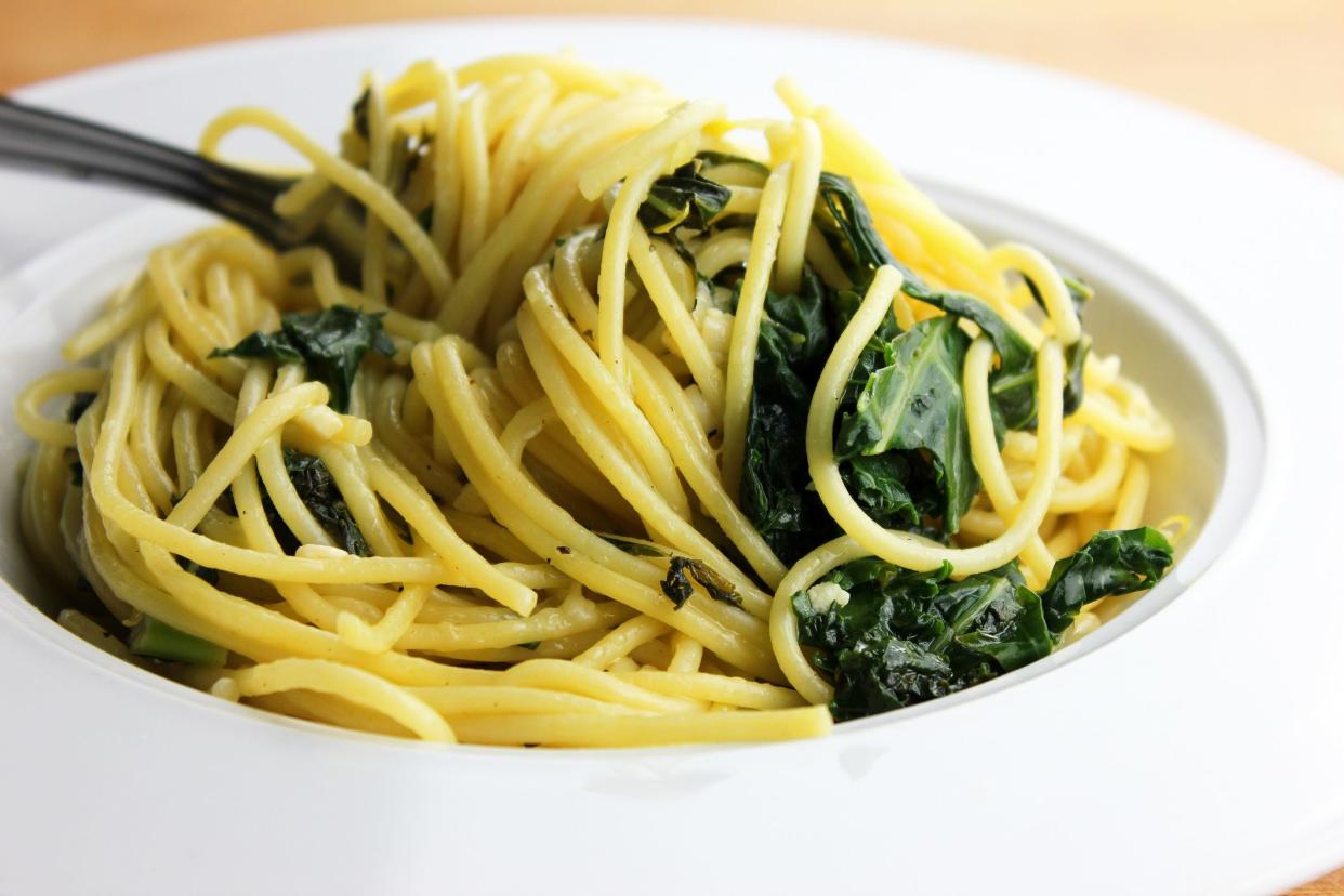 A bowl of garlic spaghetti with kale, lemon and Romano cheese