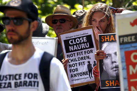 Protesters react as they hold placards and listen to speakers during a rally in support of refugees in central Sydney, Australia, October 19, 2015. REUTERS/David Gray/File photo