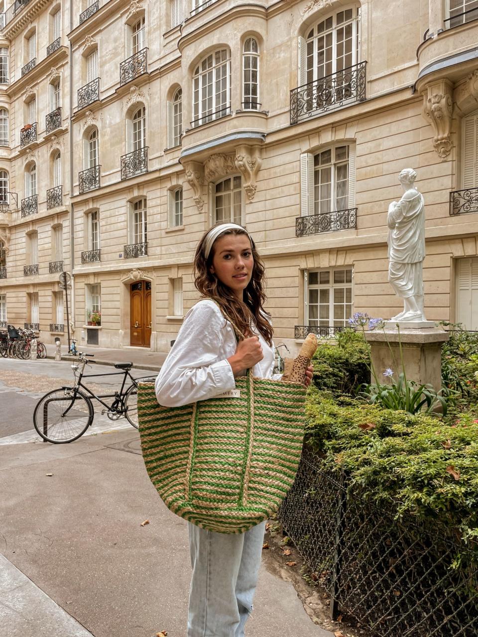 A woman holding a large bag in France.