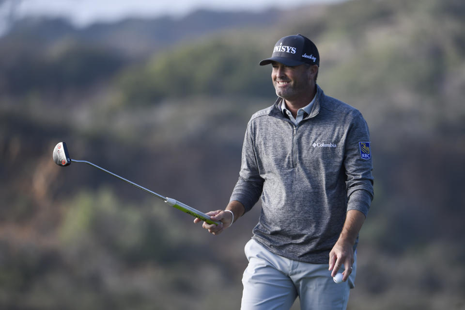 Ryan Palmer raises his putter after hitting a birdie putt on the 17th hole of the North Course at Torrey Pines Golf Course during the second round of the Farmers Insurance golf tournament Friday, Jan. 24, 2020, in San Diego. (AP Photo/Denis Poroy)