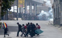 <p>Farmers clash with riot police in the background as another group of demonstrators runs across the street during a protest by coca leaf farmers in La Paz, Bolivia, Tuesday, Feb. 21, 2017. The farmers from a region north of La Paz known as Los Yungas, were dispersed by police with tear gas bombs during a protesting march, after a three-day vigil near the government palace and the National Congress where they had gathered to protest a bill they believe favors coca leaf farmers represented by President Evo Morales. (AP Photo/Juan Karita) </p>