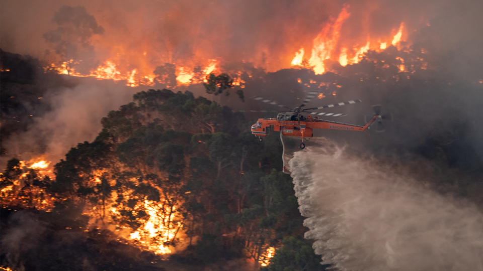 A firefighting helicopter battling a bushfire in Victoria’s East Gippsland region on December 31, 2019. Source: AAP