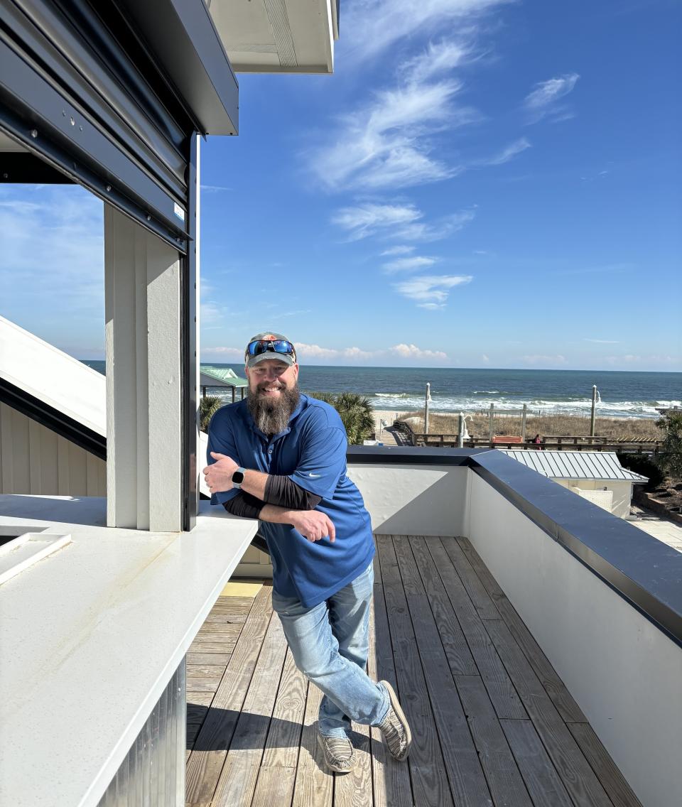 Roger Monk stands at what will be the roof-top bar with ocean views of The Tropical, a restaurant and bar set to open spring 2024.