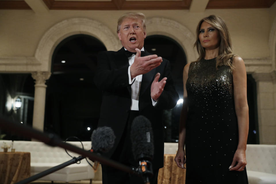 President Donald Trump speaks to the media about the situation at the U.S. embassy in Baghdad, from his Mar-a-Lago property, Tuesday, Dec. 31, 2019, in Palm Beach, Fla., as Melania Trump stands next to him. (AP Photo/ Evan Vucci)