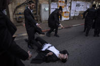 Ultra-Orthodox Jews celebrate after drinking alcohol during the Jewish holiday of Purim, in the Mea Shearim ultra-Orthodox neighborhood of Jerusalem, Sunday, Feb. 28, 2021. The Jewish holiday of Purim commemorates the Jews' salvation from genocide in ancient Persia, as recounted in the biblical Book of Esther. (AP Photo/Oded Balilty)