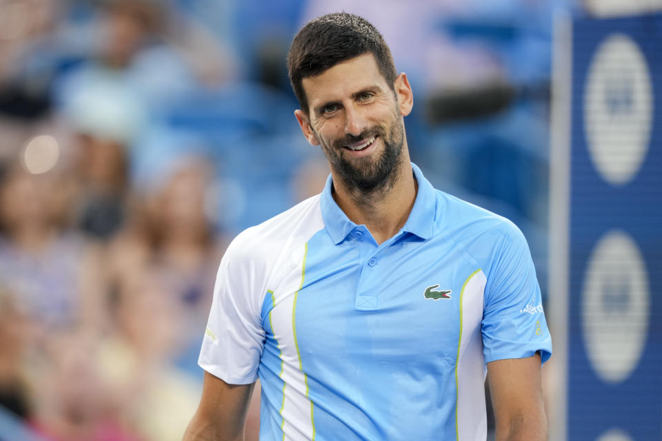 Novak Djokovic smiles on court.