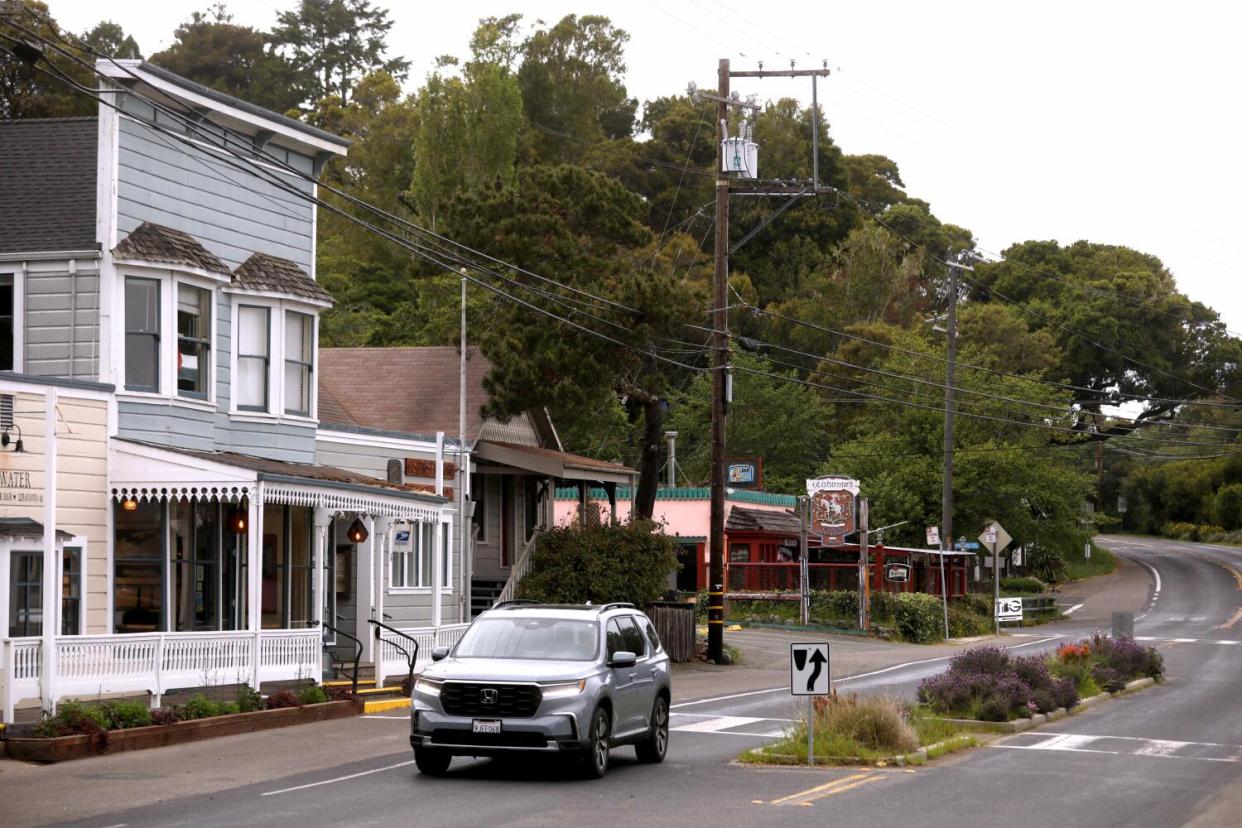 A car drives through the small town of Inverness, California.