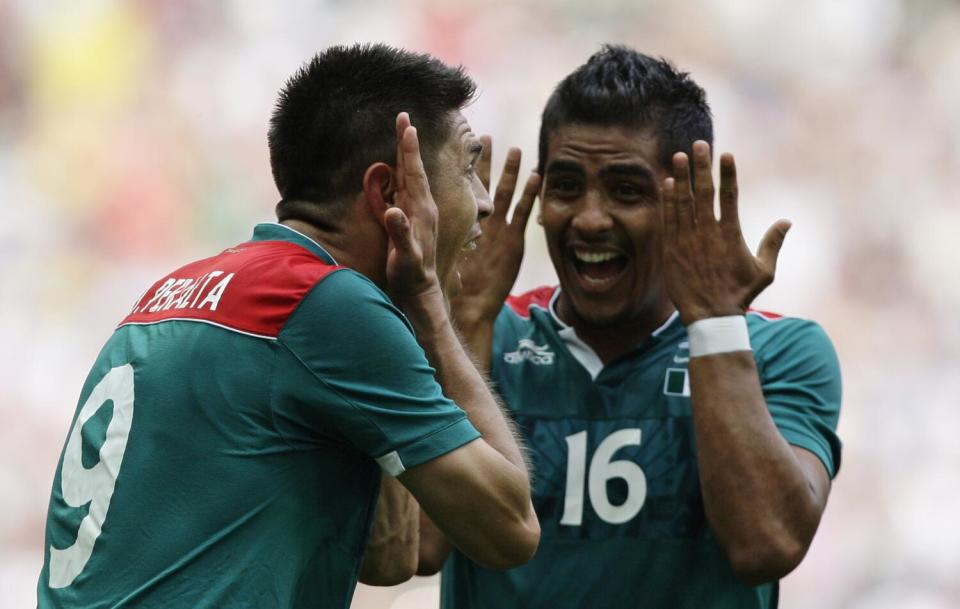 Mexico's Oribe Peralta, left, and teammate Miguel Ponce (16)