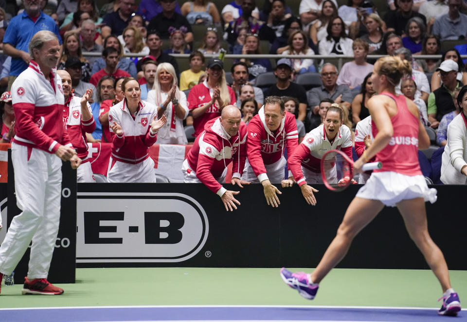 Members of the Swiss team congratulate Viktorija Golubic, right, after winning the first set against Madison Keys of the United States, during their playoff-round Fed Cup tennis match, Saturday, April 20, 2019, in San Antonio. (AP Photo/Darren Abate)