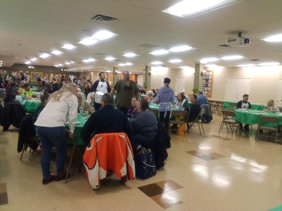 People gathered at tables in St. James Hall for "Faithful Feast Supper."