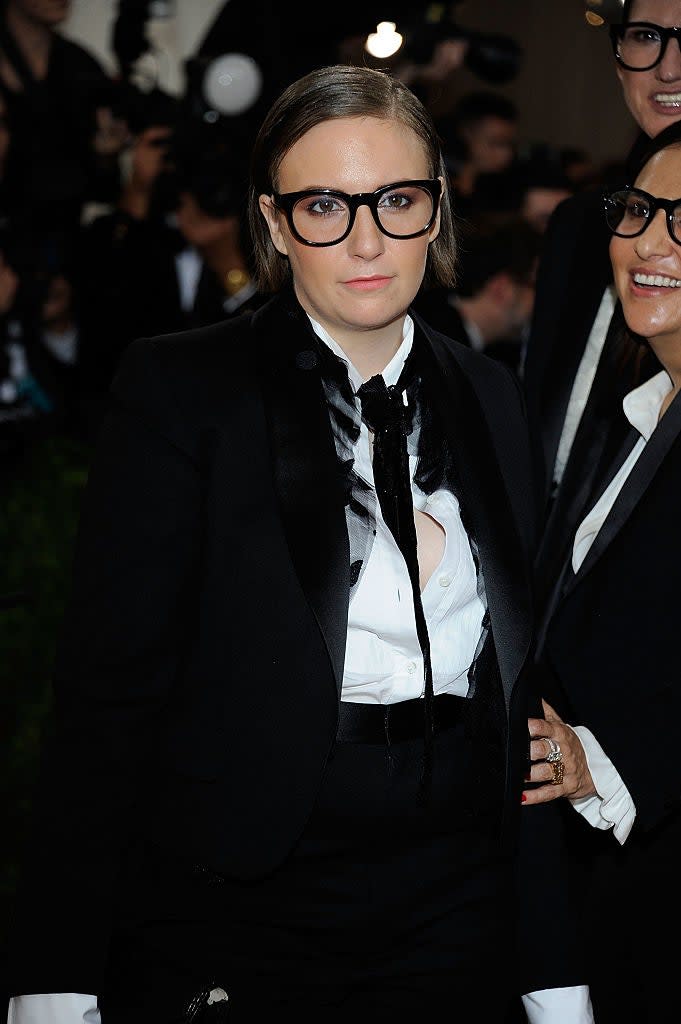 Lena Dunham in a tuxedo with a frilled shirt at an event